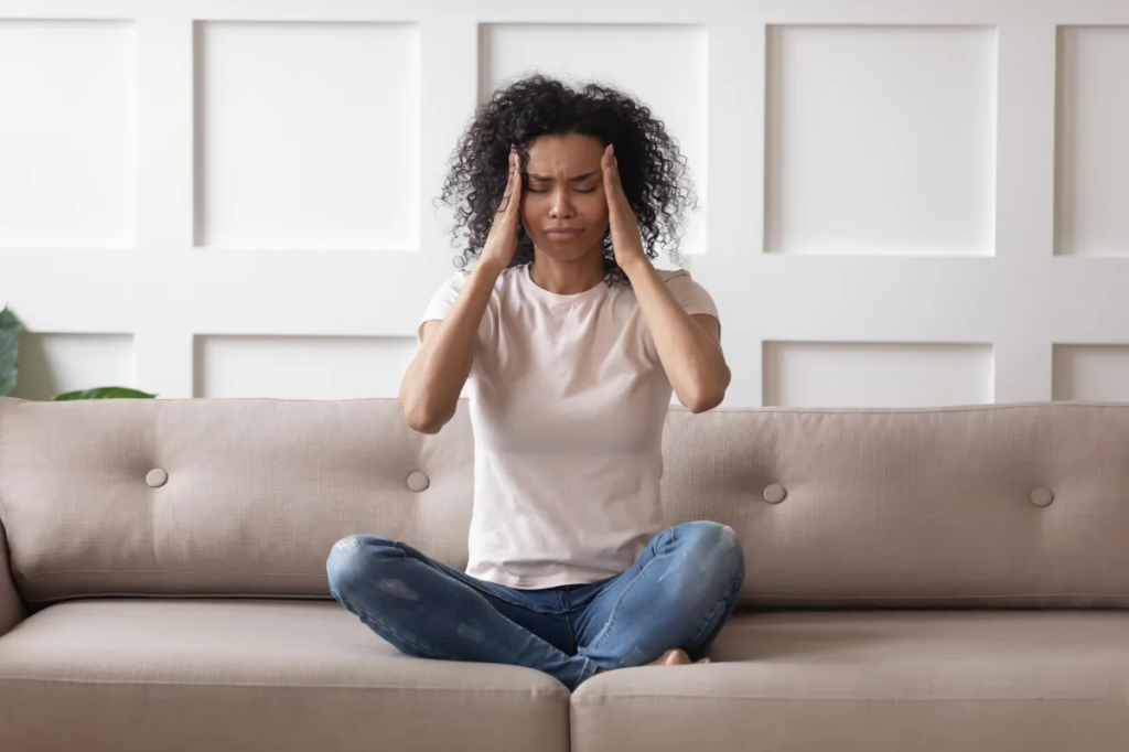 Woman seating on a sofa with signs of mental distress